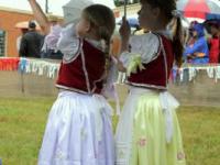 Kids in folklore costumes hiding from rain